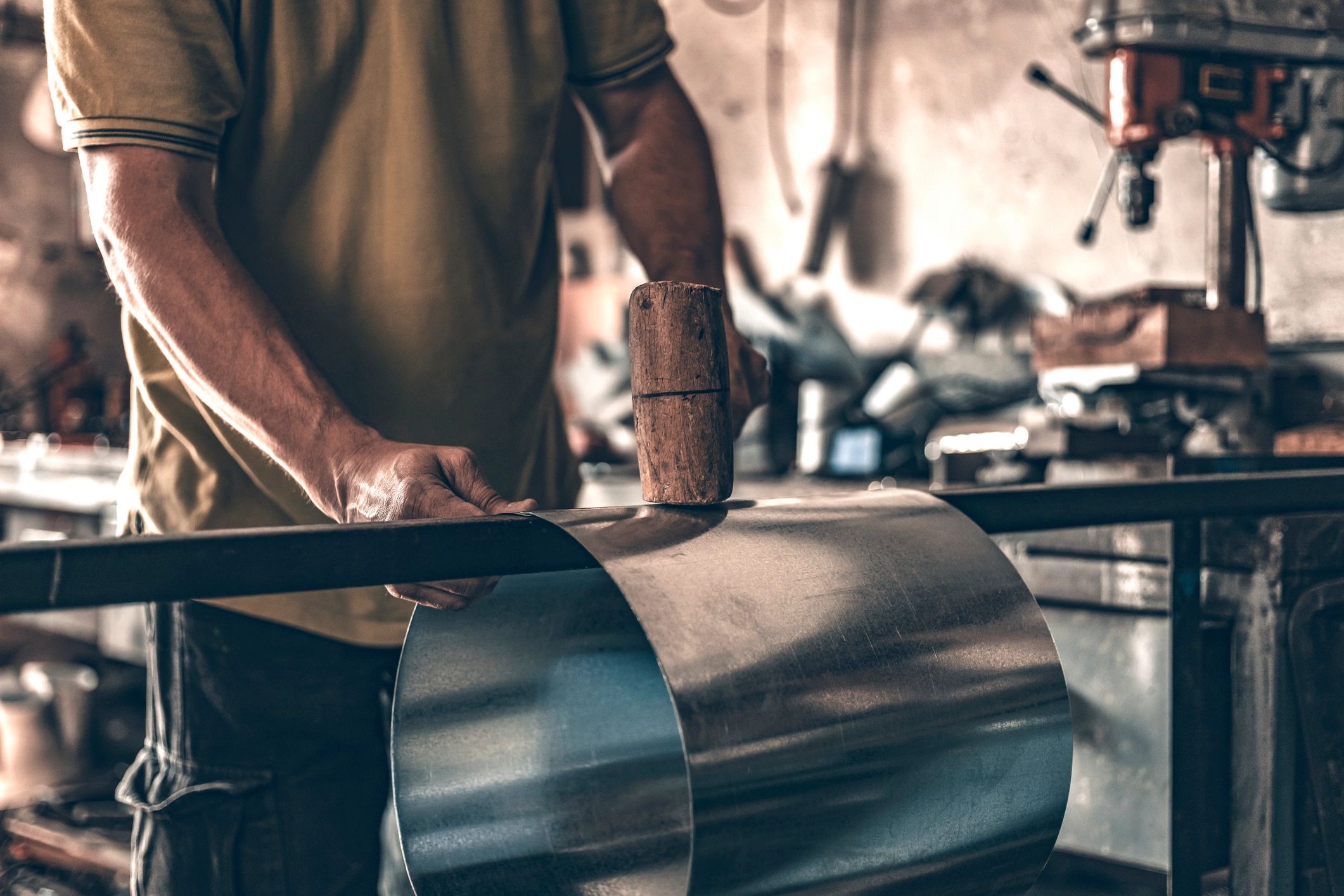 Craftsperson shaping sheet metal for custom flashing fabrication
