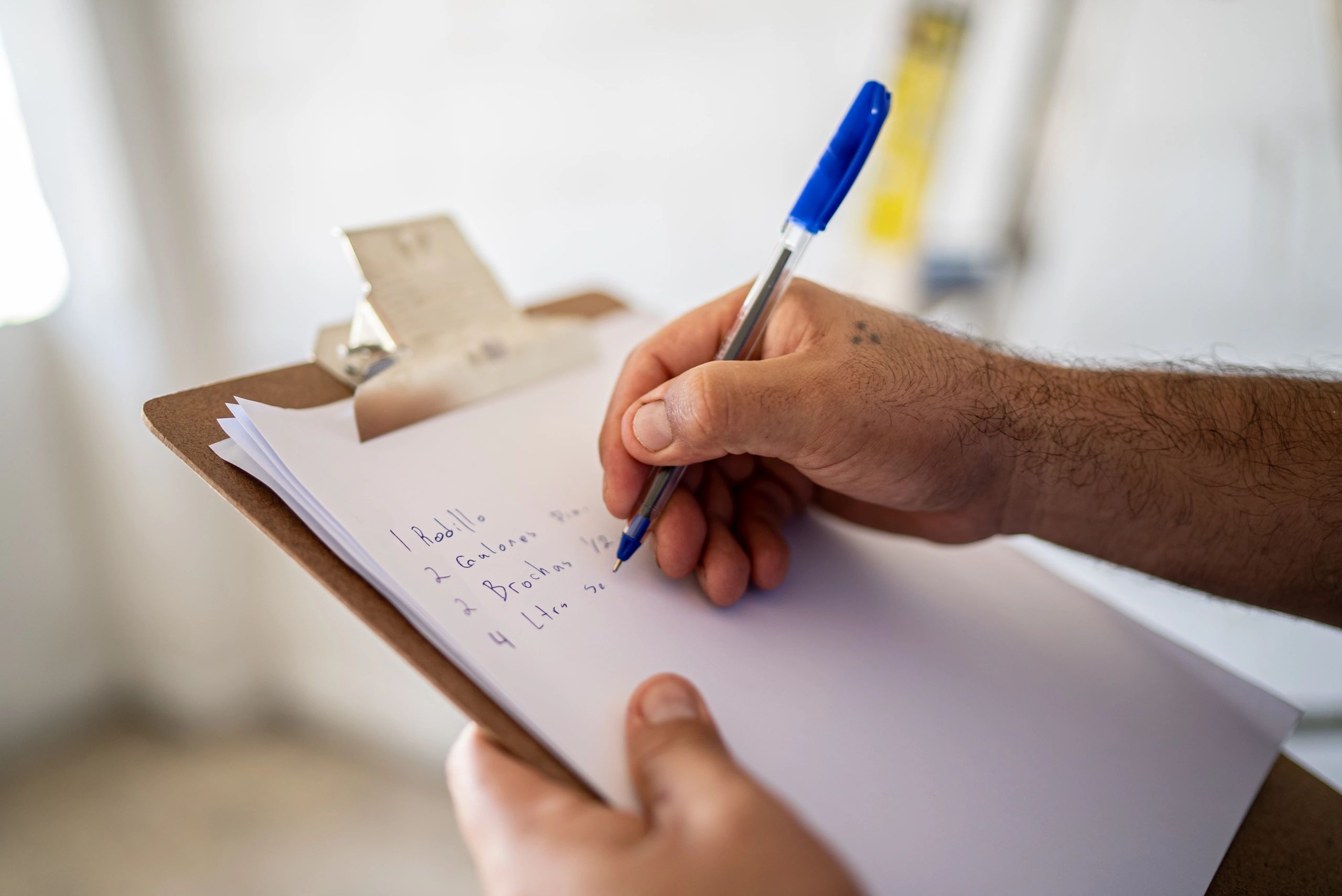 Project manager documenting roof conditions on a clipboard for CapEx planning