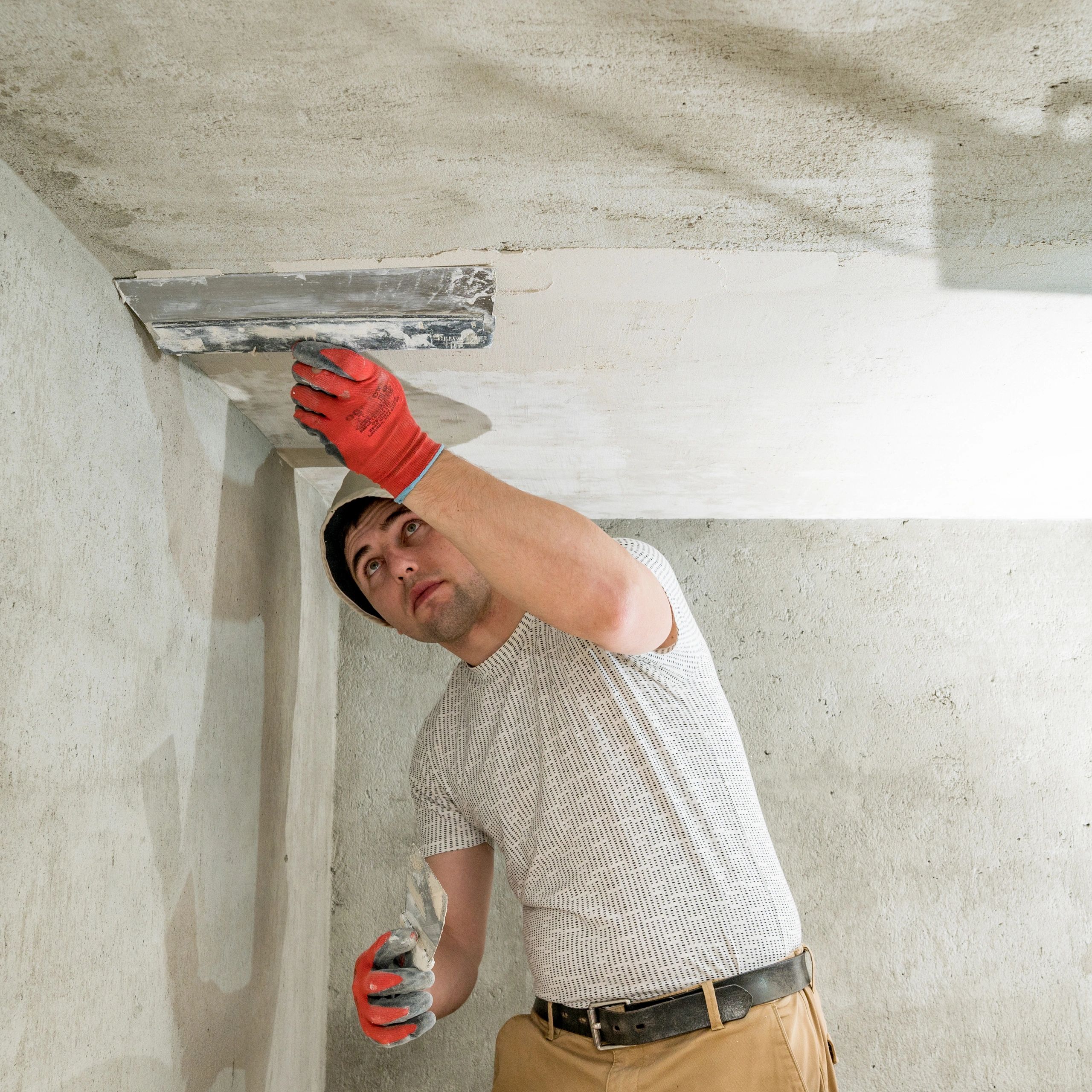 Worker applying concrete mortar during concrete restoration repair