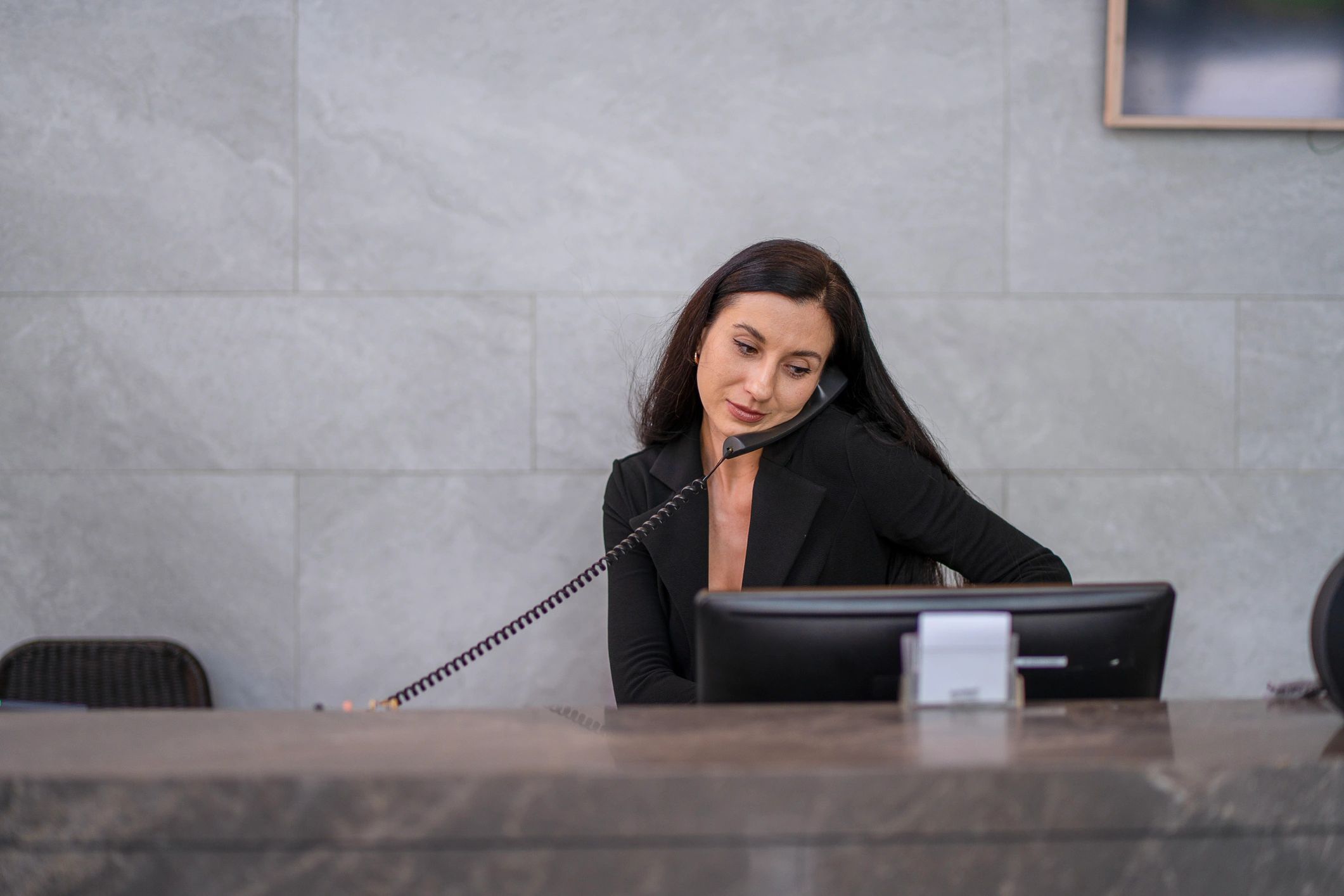 Professional receptionist taking a call at a service desk