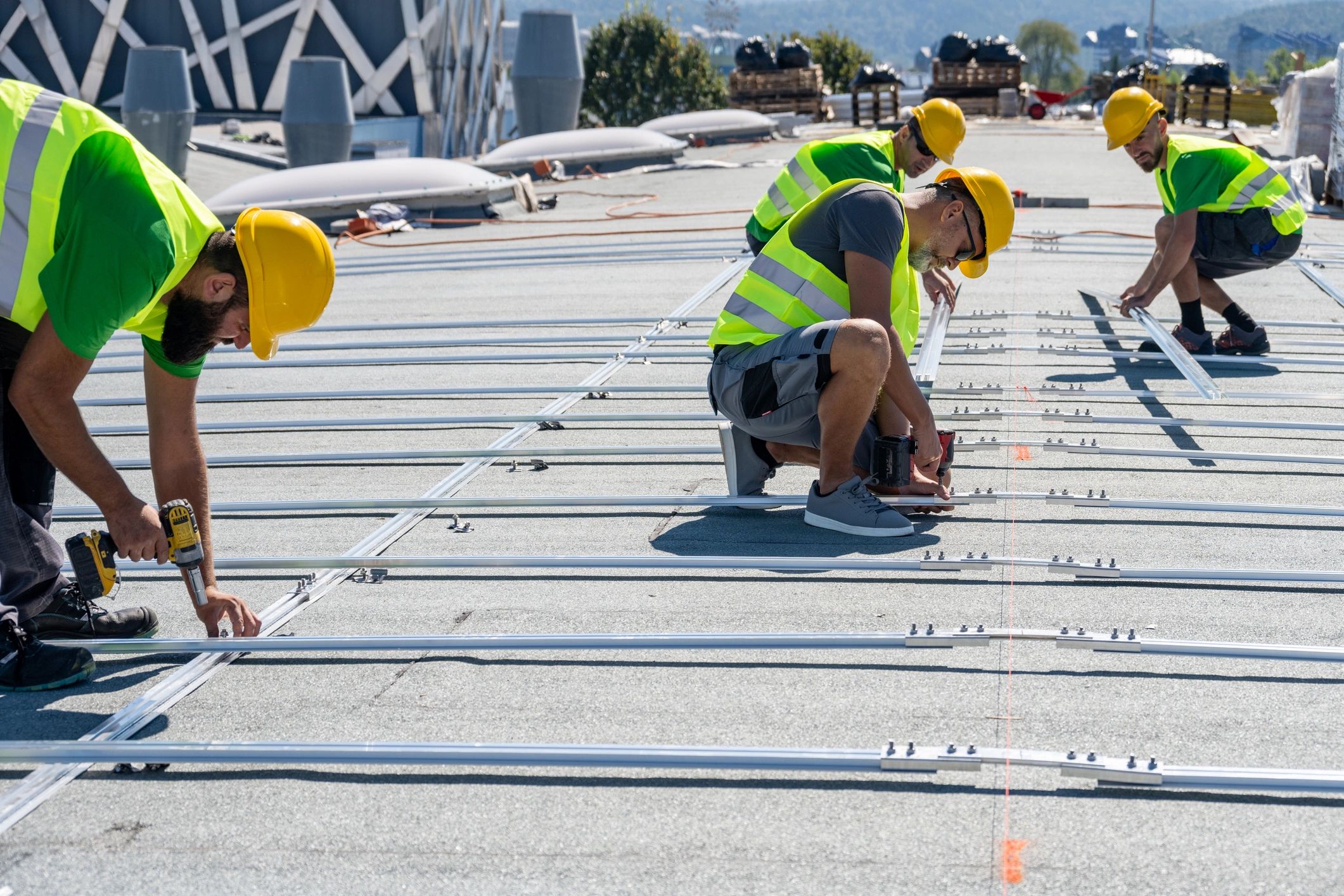 Technicians working on a rooftop installation with safety gear